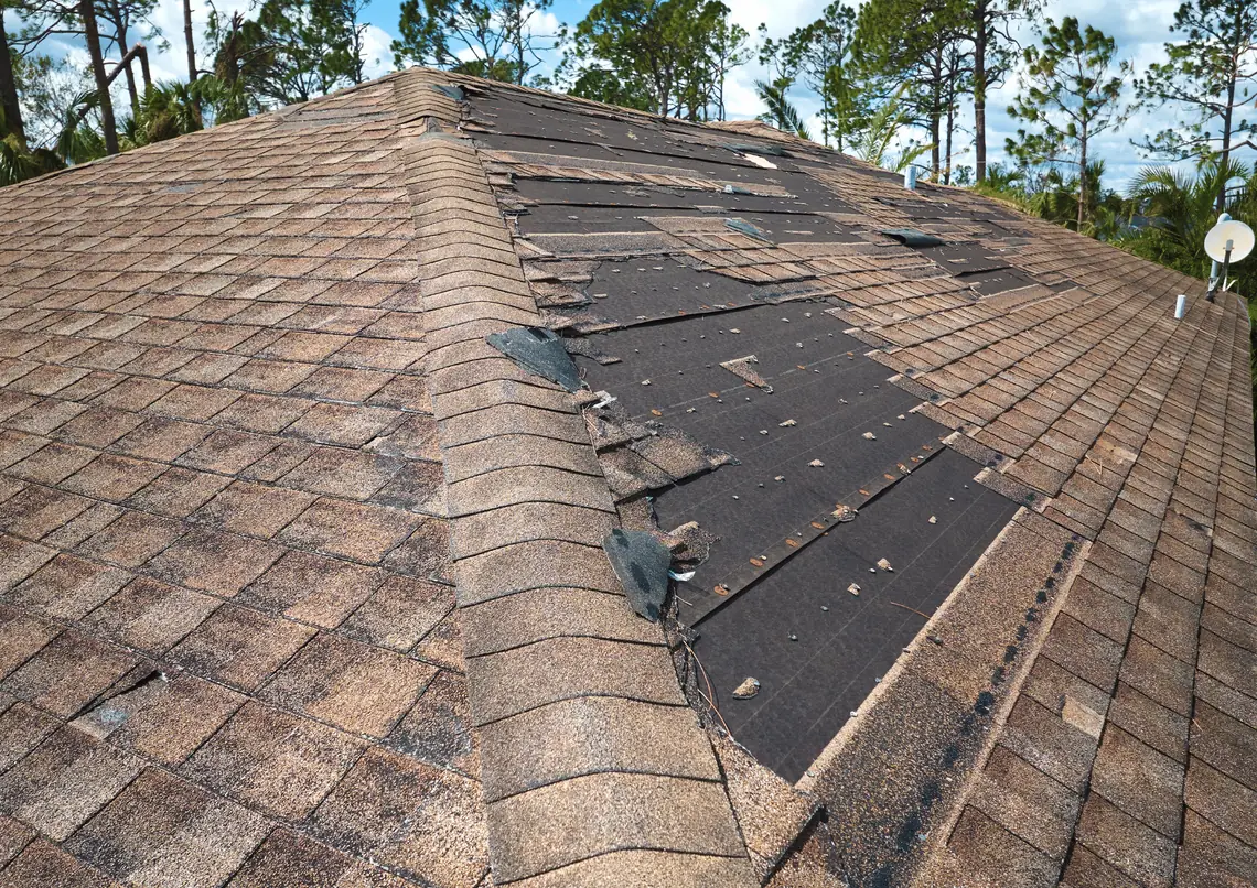 Shingle roof with missing shingles exposing the underlayment