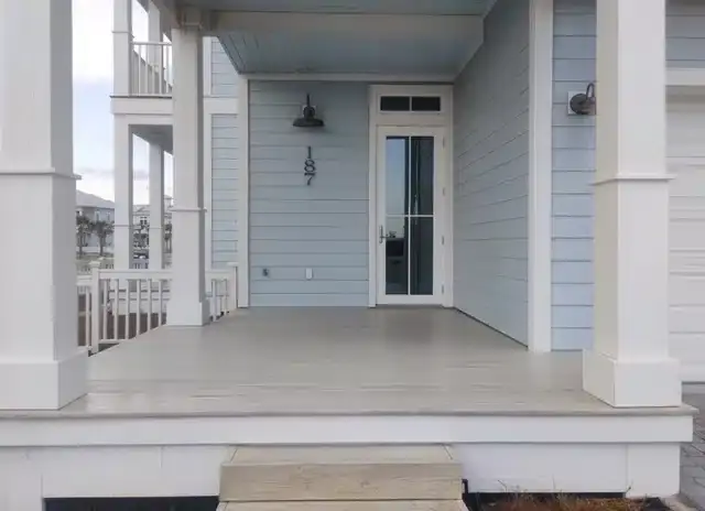 Exterior home renovation project by Buffalo Roofing & Exteriors featuring light blue siding and a deck.