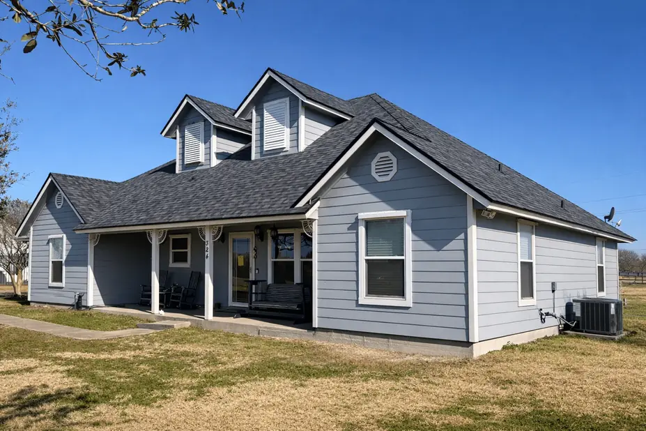 Commercial roofing project featuring a gray house with a new roof and siding.