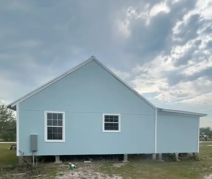 Blue house exterior roofing project in Texas