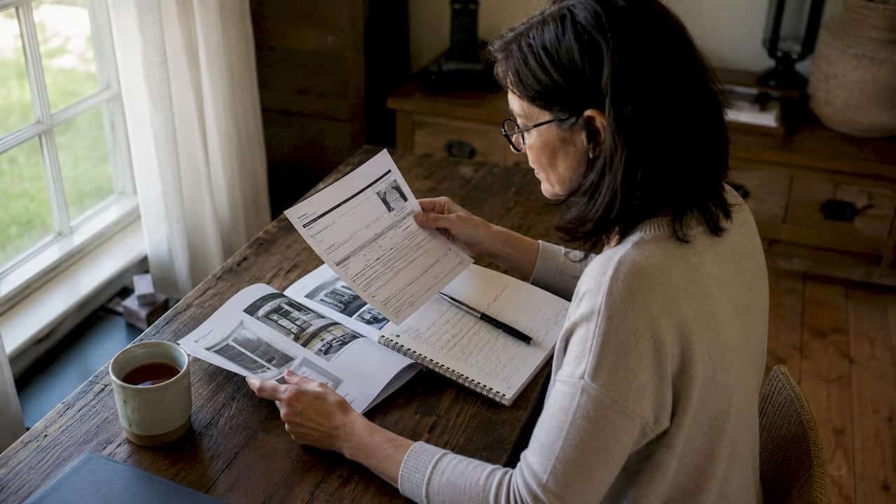 Homeowner reading window ratings at kitchen table
