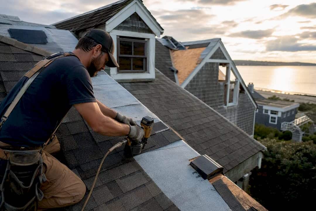 Roofer installing shingles on complex roof